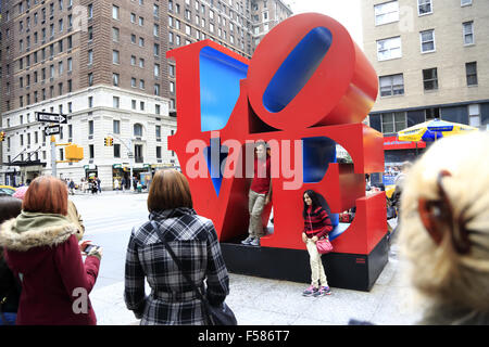 Visitors having their photos taken in front of the Love sculpture at 6th Avenue. midtown Manhattan, New York City, USA Stock Photo