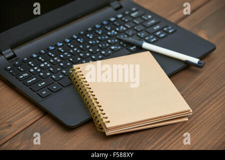 laptop computer and memo note with ballpoint pen on a wooden desk Stock Photo