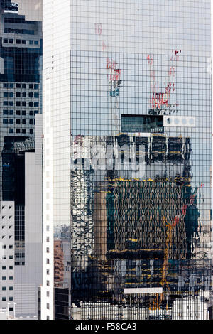 Umeda Sky building, Osaka. Grass sided two tower building connected at the top. Abstract reflection in windows of construction of another office block. Stock Photo