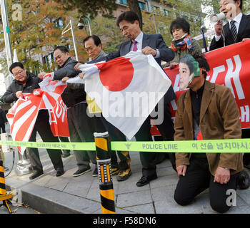 Seoul, South Korea. 30th Oct,k 2015. Activists from the National Solidarity to Defend Dokdo, tear Japanese flags as an activist (R) wears a mask resembling Japanese Prime Minister Shinzo Abe during an anti-Japan protest near the Japanese embassy in Seoul, South Korea. Japanese Prime Minister Shinzo Abe and Chinese Premier Li Kequiang will visit Seoul to hold summit talks with South Korean President Park Geun-hye from October 31 - November 2, 2015. Credit:  Lee Jae-Won/AFLO/Alamy Live News Stock Photo