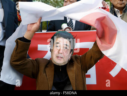 Seoul, South Korea. 30th Oct,k 2015. An activist from the National Solidarity to Defend Dokdo, wears a mask resembling Japanese Prime Minister Shinzo Abe and holds a Japanese flag torn by other activists during an anti-Japan protest near the Japanese embassy in Seoul, South Korea. Japanese Prime Minister Shinzo Abe and Chinese Premier Li Kequiang will visit Seoul to hold summit talks with South Korean President Park Geun-hye from October 31 - November 2, 2015. Credit:  Lee Jae-Won/AFLO/Alamy Live News Stock Photo