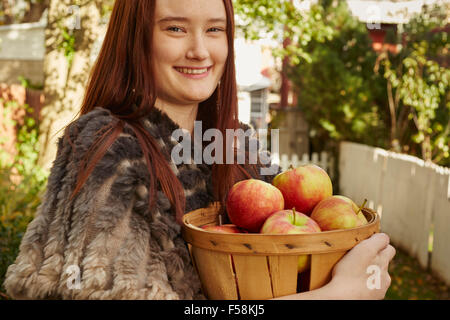 Young Woman With Basket of Apples Stock Photo