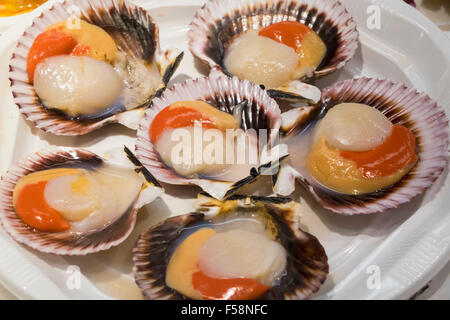 Scallops in shells on plate of hors-d'oeuvres or entradas in food counter in Spanish market in Madrid Stock Photo