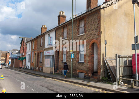 A terrace of boarded up empty houses and shops on Woodbridge Road, Guildford, Surrey Stock Photo