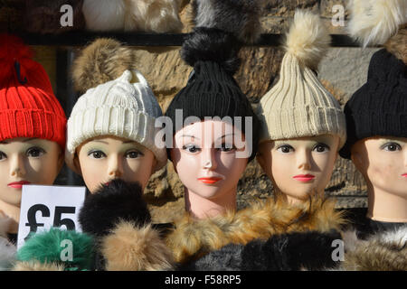 Woolly hats for sale displayed on mannequin heads at the annual Pack Monday Fair, Sherborne, Dorset, England Stock Photo