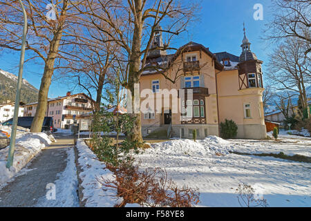 View of the charming house in Bavarian Village Garmisch-Partenkirchen on a sunny winter day. Garmisch-Partenkirchen is a mountain resort in Bavaria, southern Germany, in the heart of the Alps Stock Photo