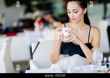 Beautiful woman drinking tea in restaurant while waiting for her meal Stock Photo