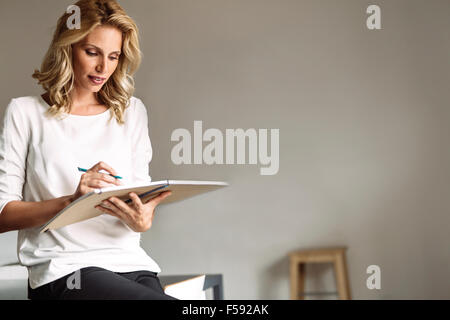 Beautiful woman holding a book and reading Stock Photo