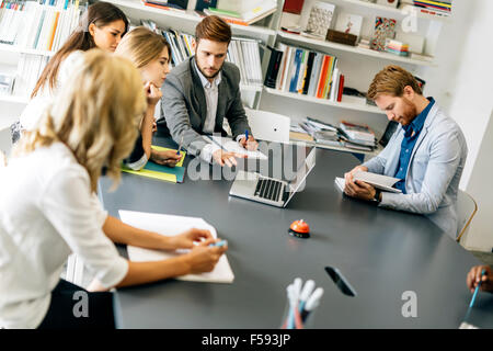 Colleagues brainstorming in office while pointing out new ideas on laptop Stock Photo