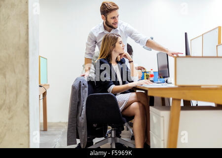 Colleagues working on a computer in an office Stock Photo