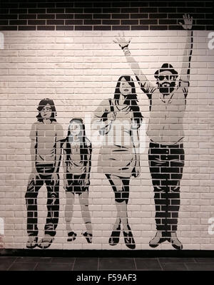 New grunge white and black brick wall with painted happy family Stock Photo