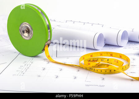 Tape measure placed on the desk, filled with building plans. In order to work in a building Stock Photo