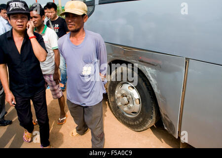 People are gathered near the aftermath of a collision between a Toyota car and a tour bus on National Road 6 near Skun, Cambodia Stock Photo