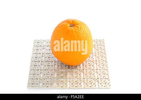Orange on plastic grid with spikes isolated on white background Stock Photo