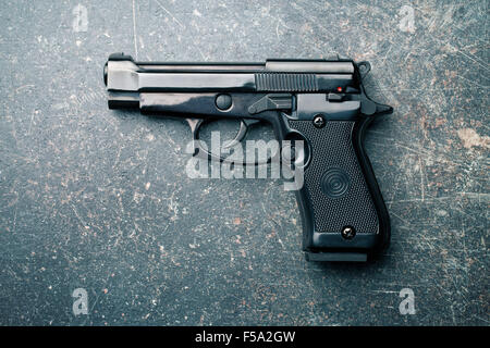 black handgun on old crackle background Stock Photo