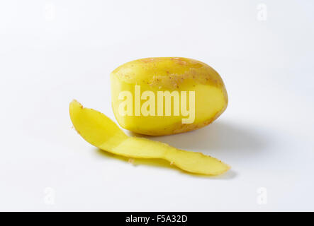 Single fresh potato, partially peeled Stock Photo