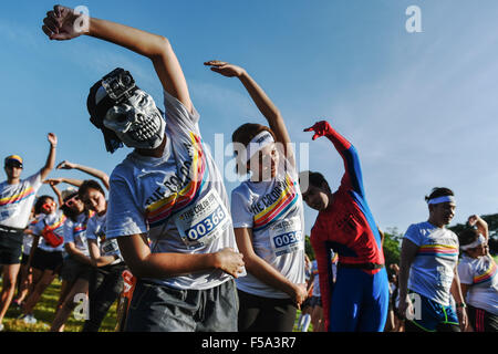 Bangkok, Thailand. 31st Oct, 2015. Participants of the Color Run Bangkok do warm-up exercises at the Suan Rod Fai park in Bangkok, Thailand, on Oct. 31, 2015. The Color Run is a 5km public paint race that originated in the U.S. in 2011. In a typical Color Run race, participants will end up covered in a mixture of colored powders made from corn starch. Credit:  Li Mangmang/Xinhua/Alamy Live News Stock Photo