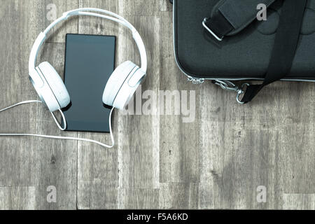 Cellphone with headphone and a briefcase background Stock Photo