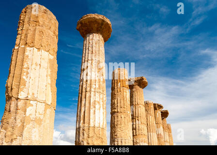 Doric columns of the Heracles temple in Agrigento with blue sky and clouds in background Stock Photo