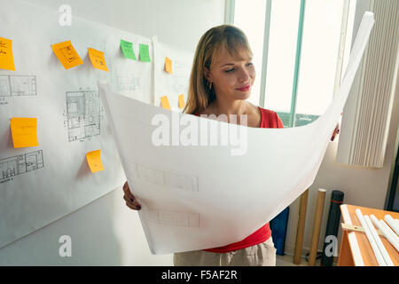 University student of Interior Design doing homeworks, reviewing housing project and completing project. The girl contemplates h Stock Photo