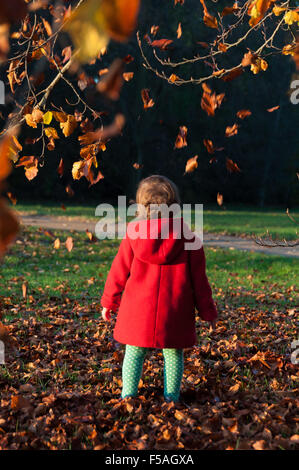 Toddler playing with autumn leaves for the first time