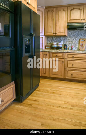 Kitchen with oak cabinets & wood floor, new appliances and granite countertops in a recently remodeled kitchen Stock Photo