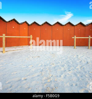 A series of numbered bathing huts on a white beach in Tuscany. Bathing huts are also known as a beach cabins or bathing boxes. Stock Photo