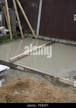 Part smoothed wet cement that is forming a shed a base Stock Photo