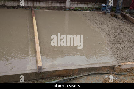 Part smoothed wet cement that is forming a shed a base Stock Photo