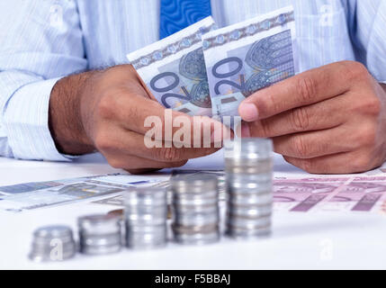 Man handling money and coins group of focus in the foreground Stock Photo
