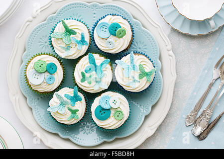 Cupcakes decorated with sugarpaste butterflies and buttons Stock Photo