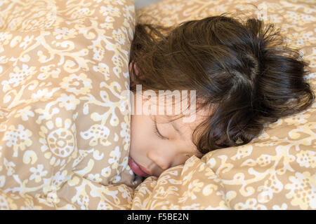 Asian child sleeping in cozy bed in morning. Stock Photo