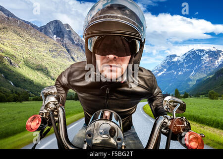Biker in helmet and leather jacket racing on the road. Stock Photo