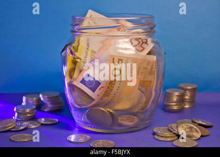 Banknotes and coins in a glass jar Stock Photo