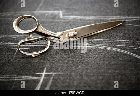 Tailors scissors lying on fabric marked in chalk Stock Photo