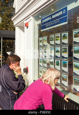 A couple looking in an estate agents window for house buying in America, Stowe, Vermont, USA Stock Photo