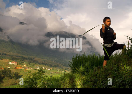 A child playing next to the rice terraces nearby of Lao Chai village. Trekking Sapa to Lao Chai. Vietnam. Stock Photo