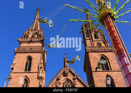 Basel, Switzerland. 1st November, 2015. A swing carousel in front of the Basel Cathedral on a beautiful sunny day at the Autumn Fair (Herbstmesse) in Basel, Switzerland. Credit:  Stephen Allen/Alamy Live News. Stock Photo