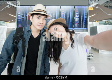 Asian couple tourist taking a selfie in airport before journey Stock Photo