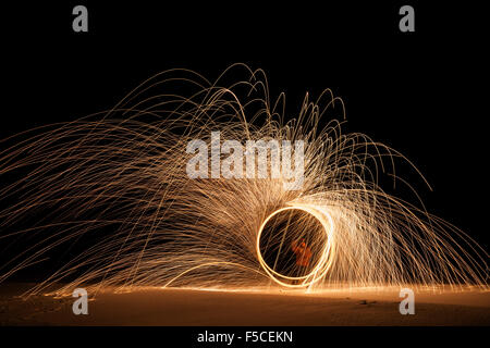 Light painting at night created by man whirling steel wool burning at the end of a rope, Ely, MN, USA Stock Photo