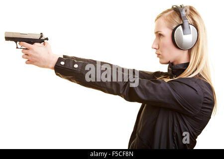 Young female shooter with pistol and ear protection Stock Photo