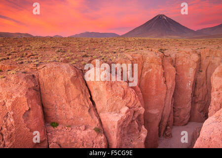 A narrow canyon with a volcano in the distance. Photographed at the foot of Volcan Licancabur in the Atacama Desert, northern Ch Stock Photo