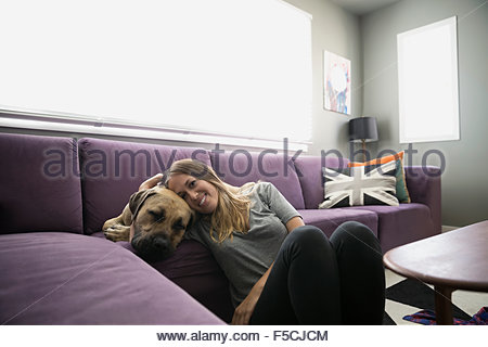 Portrait smiling woman with dog living room sofa