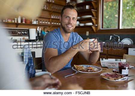Smiling young couple enjoying breakfast at kitchen table