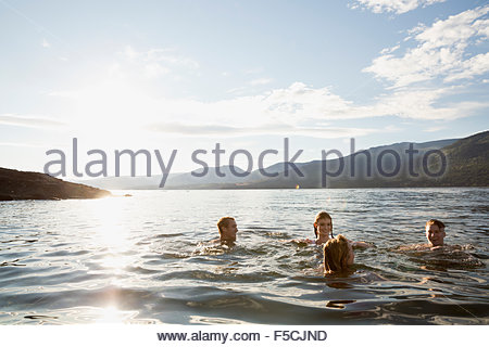 Young friends swimming in sunny lake