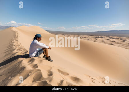 Hiker Taking a Break at the Gobi Desert Sand Dunes Stock Photo