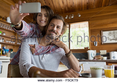 Affectionate young couple taking selfie in cabin kitchen
