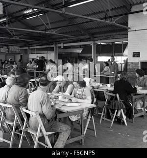 1950s historical, factory workers sitting having their lunch break in the staff canteen. Stock Photo