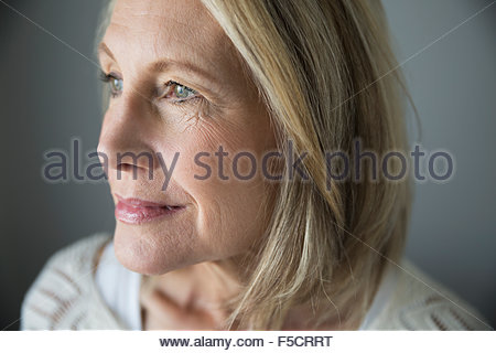 Close up portrait pensive senior woman looking away