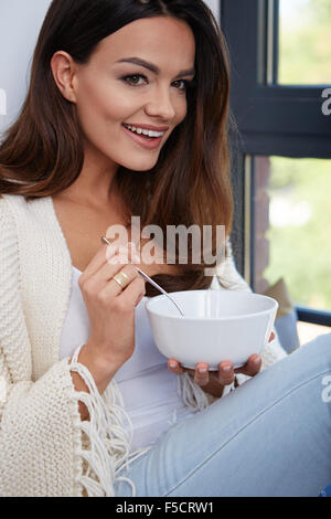Young woman eating soup.